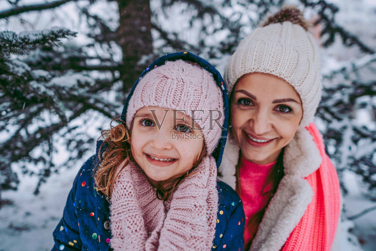 近距离的母亲和女儿在一个雪天照片摄影图片