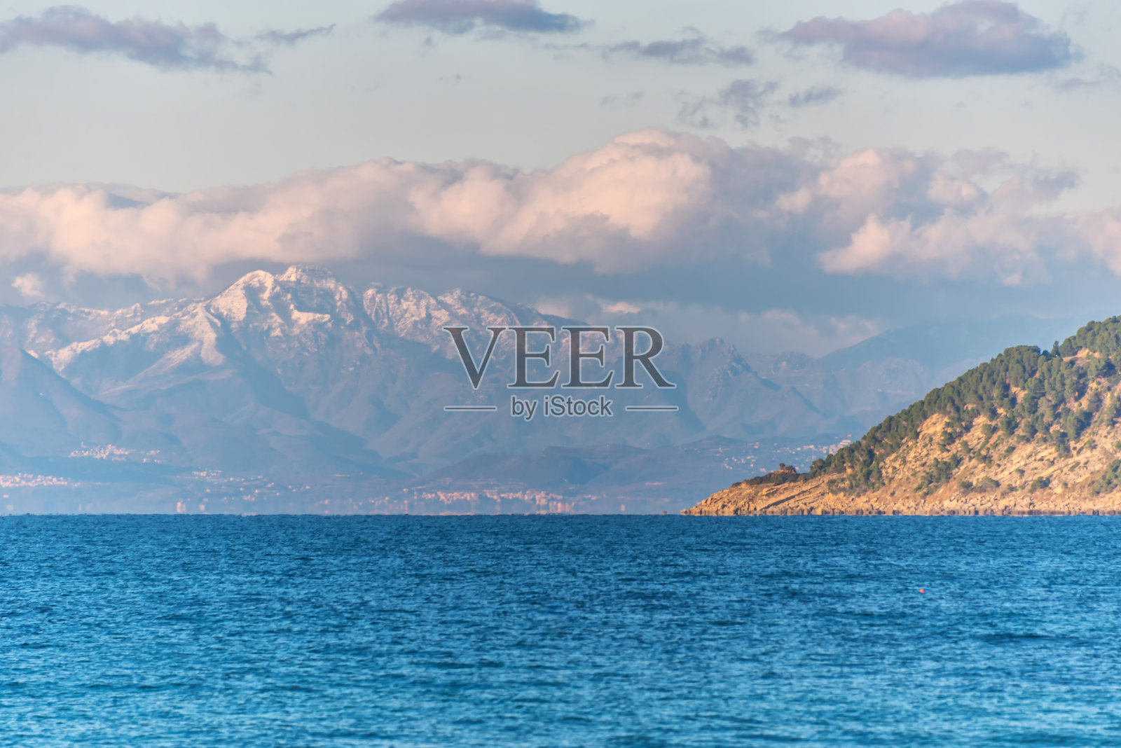 遥远的雪山沿意大利南部地中海海岸照片摄影图片