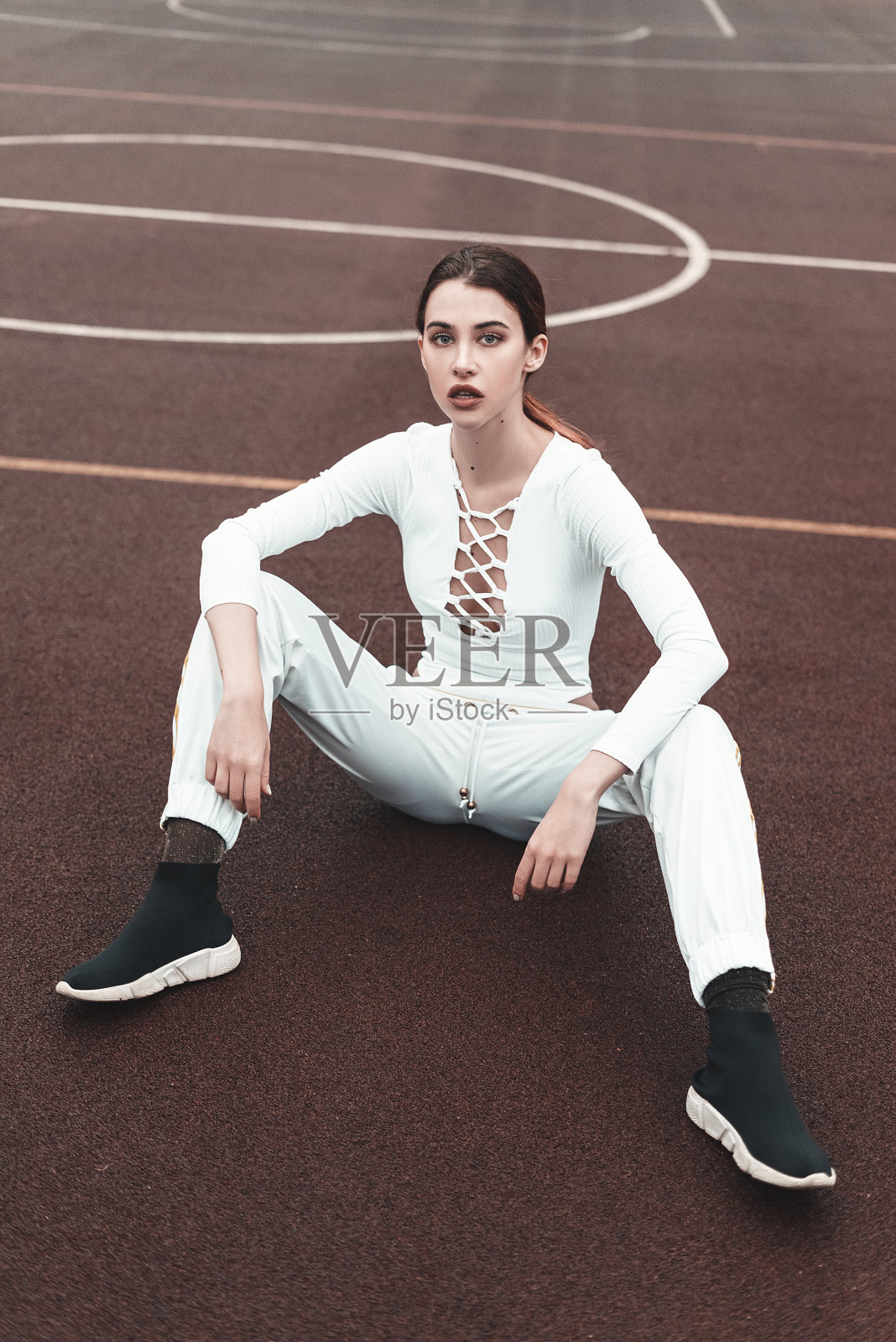 年轻漂亮的年轻女孩时尚户外写真。年轻时髦的女人在地上摆姿势照片摄影图片