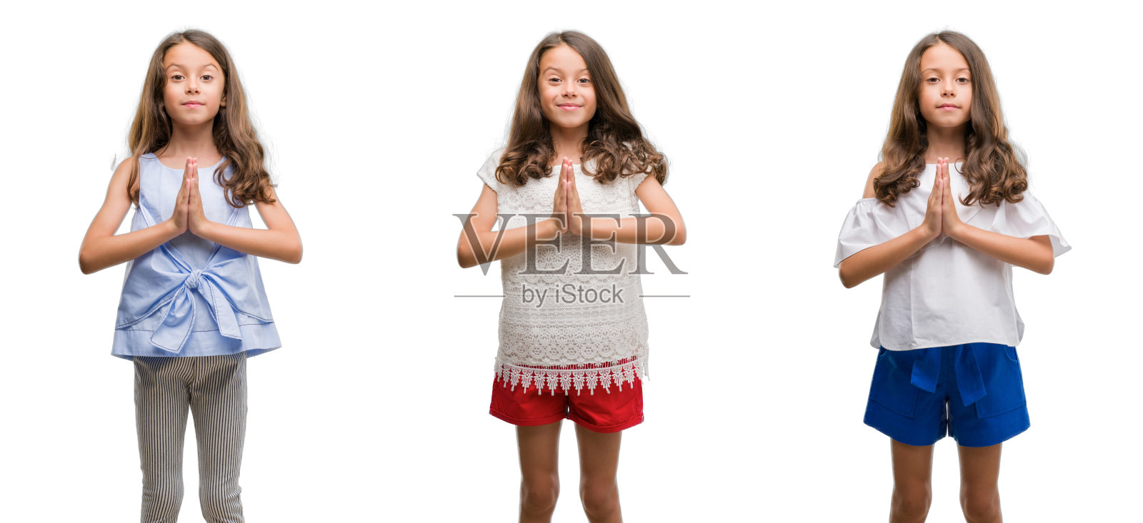 来自孤立背景的西班牙裔小孩用双手祈祷，以自信的微笑请求宽恕。照片摄影图片