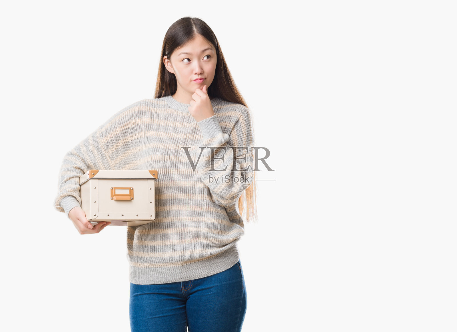 年轻的中国女子过着孤立的背景，抱着一盒严肃的脸思考着问题，非常困惑的想法照片摄影图片
