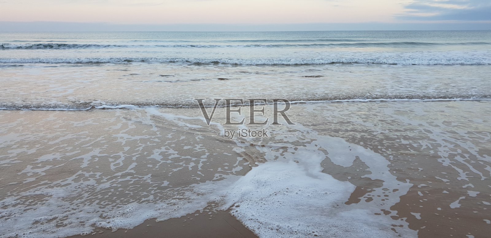 白色的海浪泡沫到达沙滩照片摄影图片