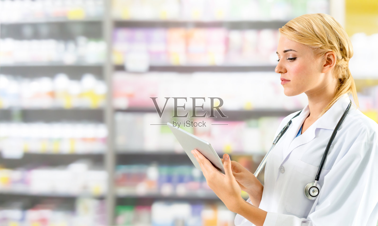 药剂师在药房使用平板电脑。照片摄影图片