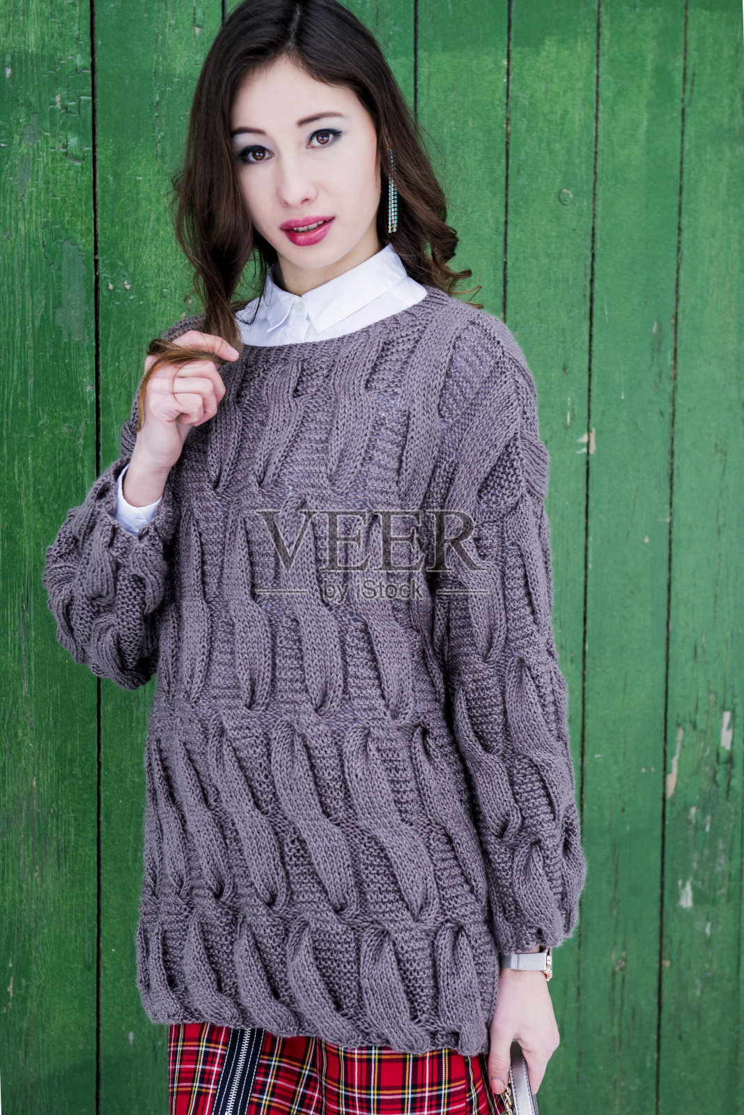 这位美丽的模特穿着一件时髦的针织毛衣摆姿势照片摄影图片