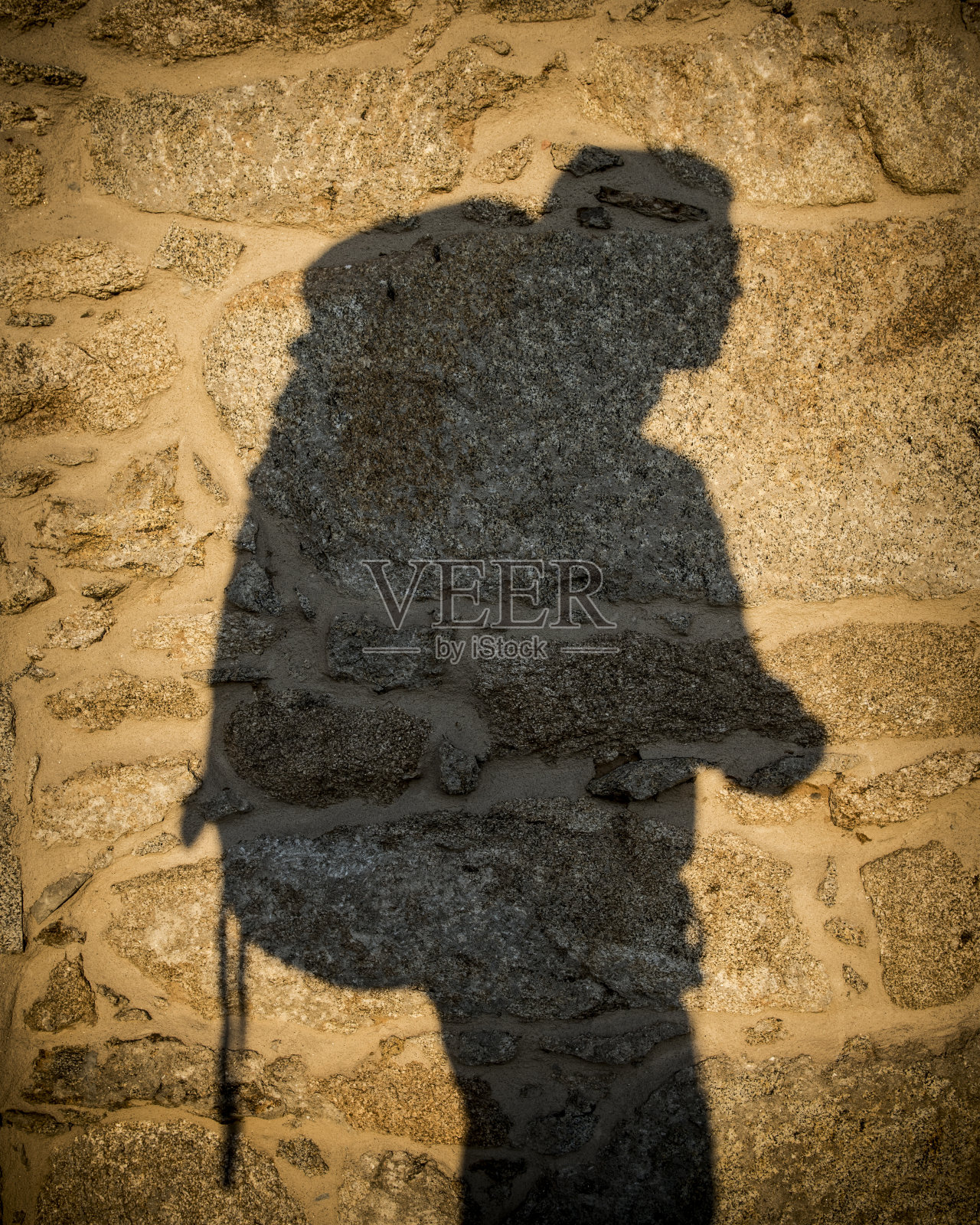 背包客在石墙上的影子照片摄影图片