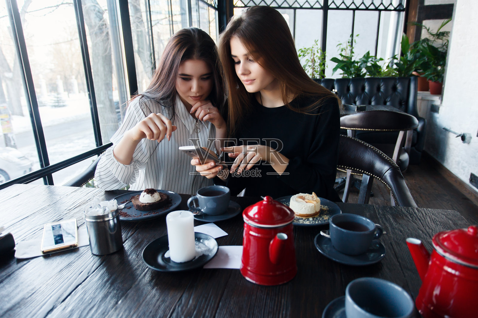 两个年轻女子在用智能手机自拍照片摄影图片