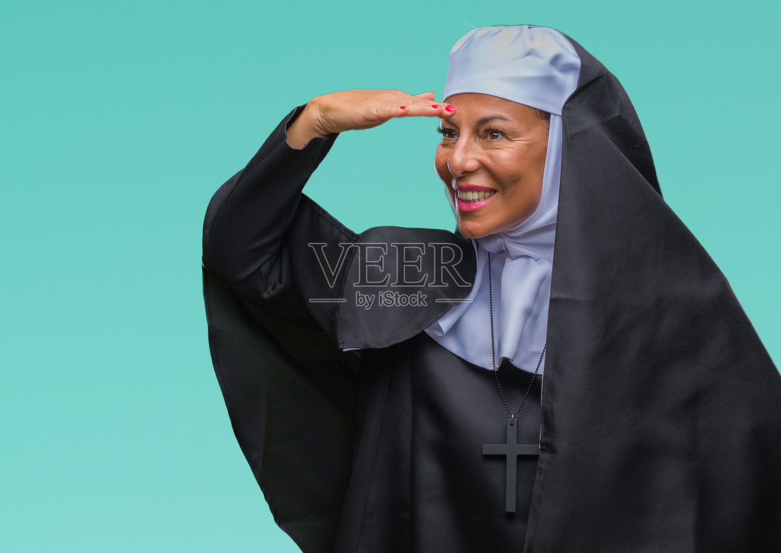 中年资深基督教天主教修女越过孤立的背景非常幸福和微笑看远与手在头上。搜索概念。照片摄影图片
