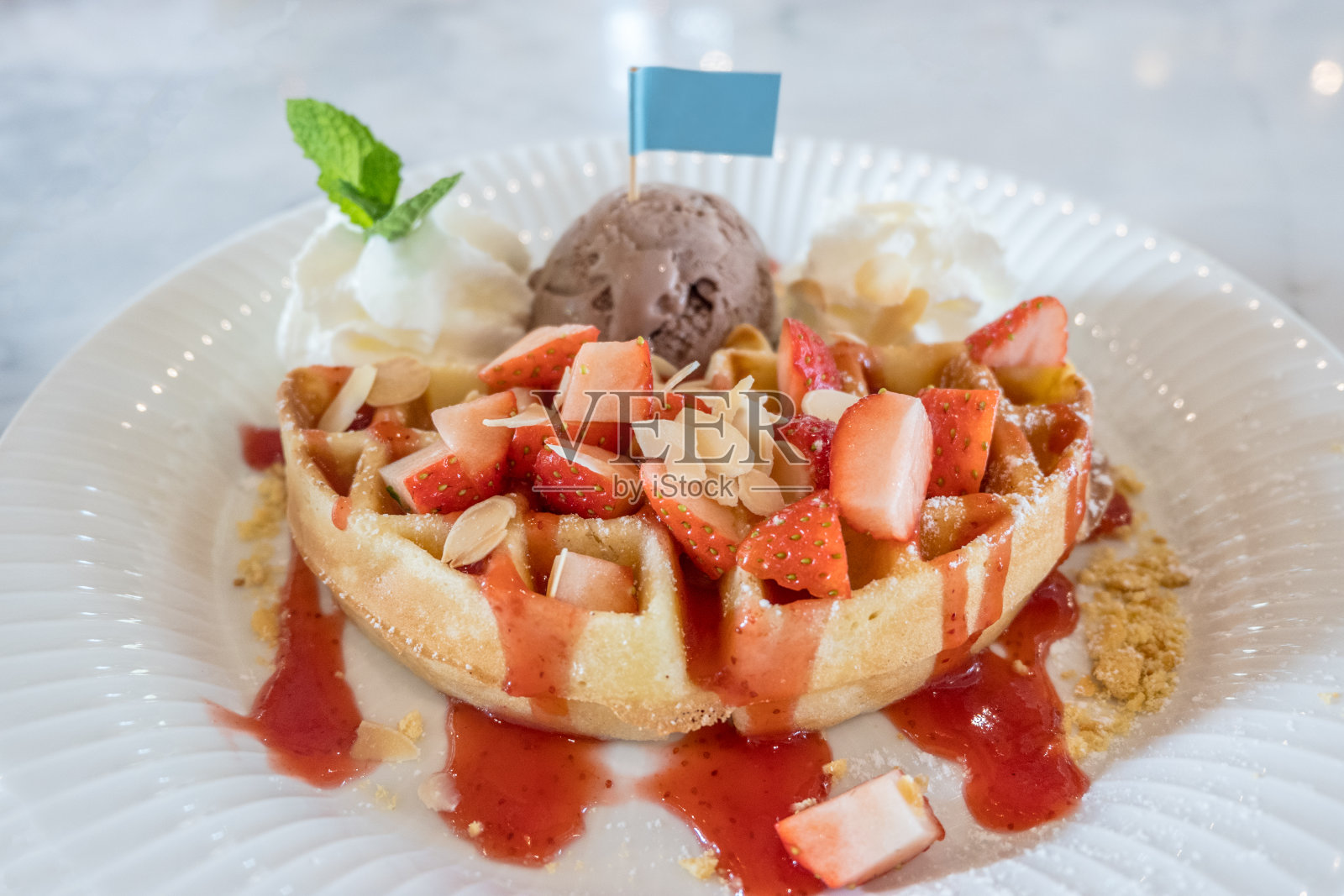 比利时全麦华夫饼，配草莓糖浆，鲜奶油，核桃和巧克力冰淇淋照片摄影图片