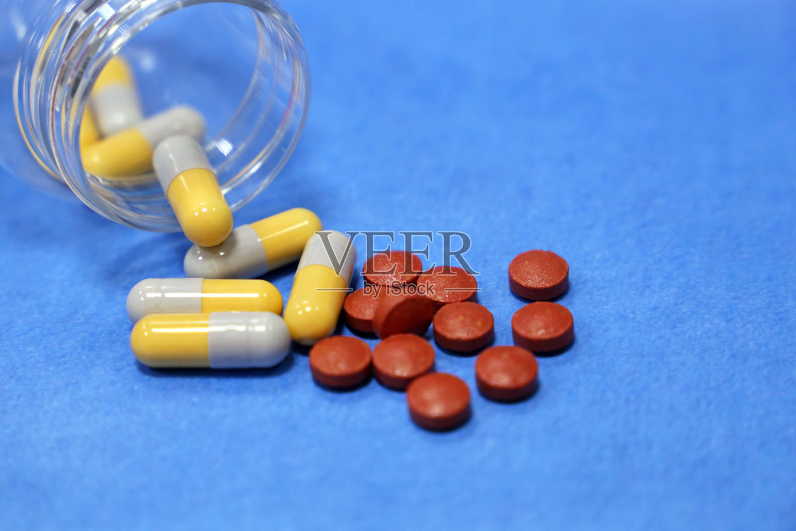蓝色背景的瓶装药片和胶囊照片摄影图片