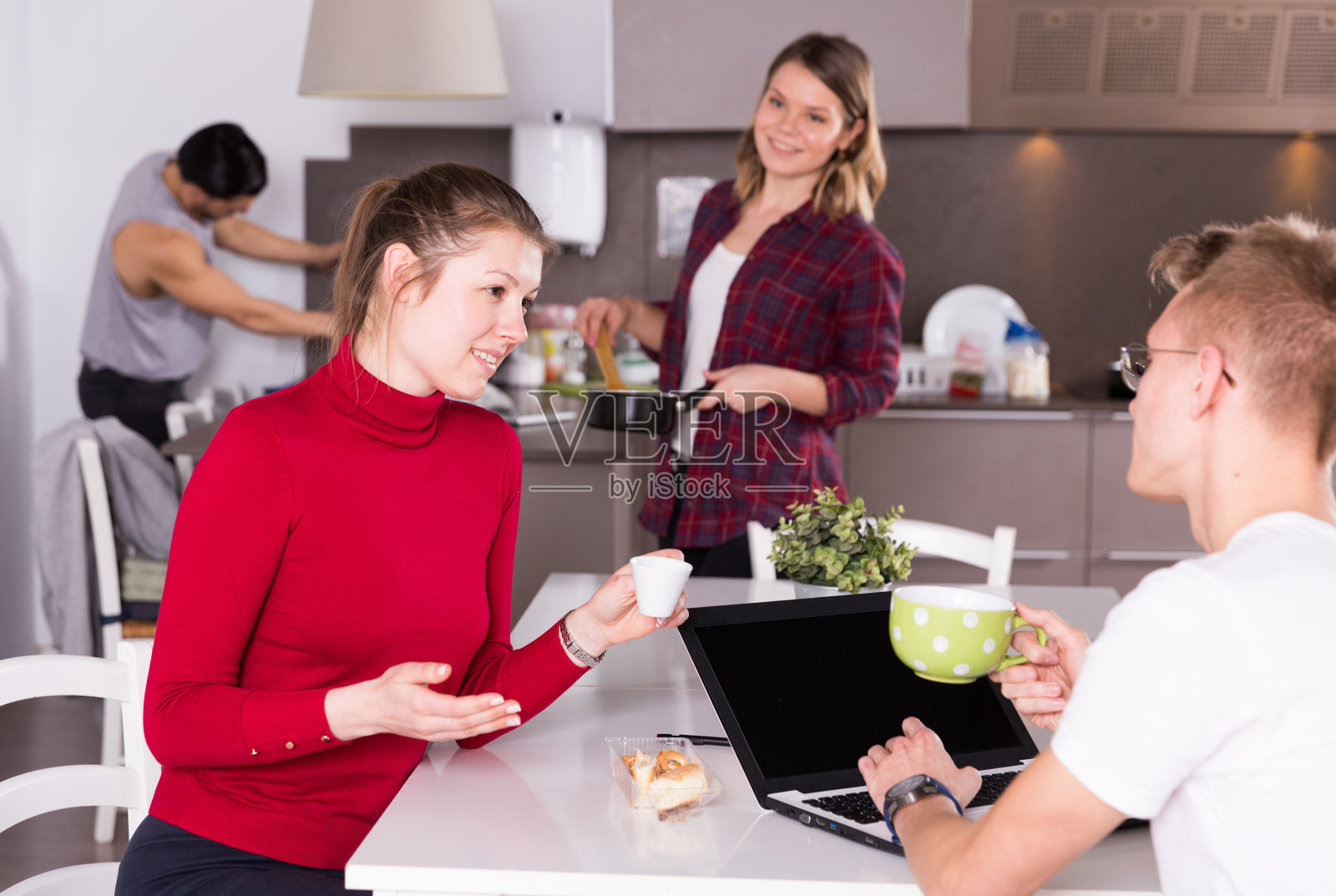 在旅社厨房里，一名女性正在帮助一名男子计划旅游行程照片摄影图片