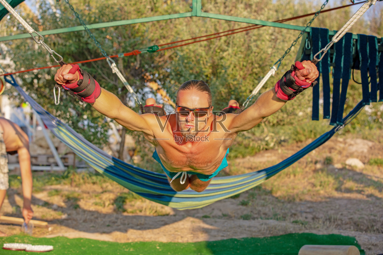 瑜伽治疗核心瑜伽摆动，苗条的年轻人绑在地板上四板与运动垫，男子发展耐力和拉伸核心照片摄影图片