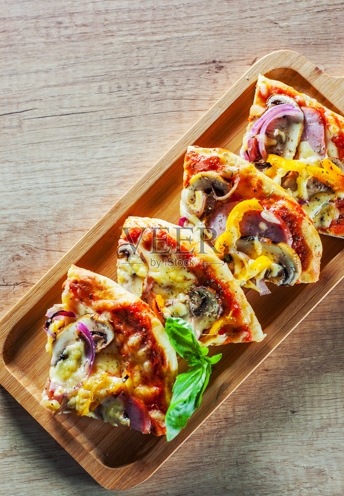 切成薄片的希腊披萨，配蘑菇，火腿，奶酪，洋葱，胡椒在木板上照片摄影图片