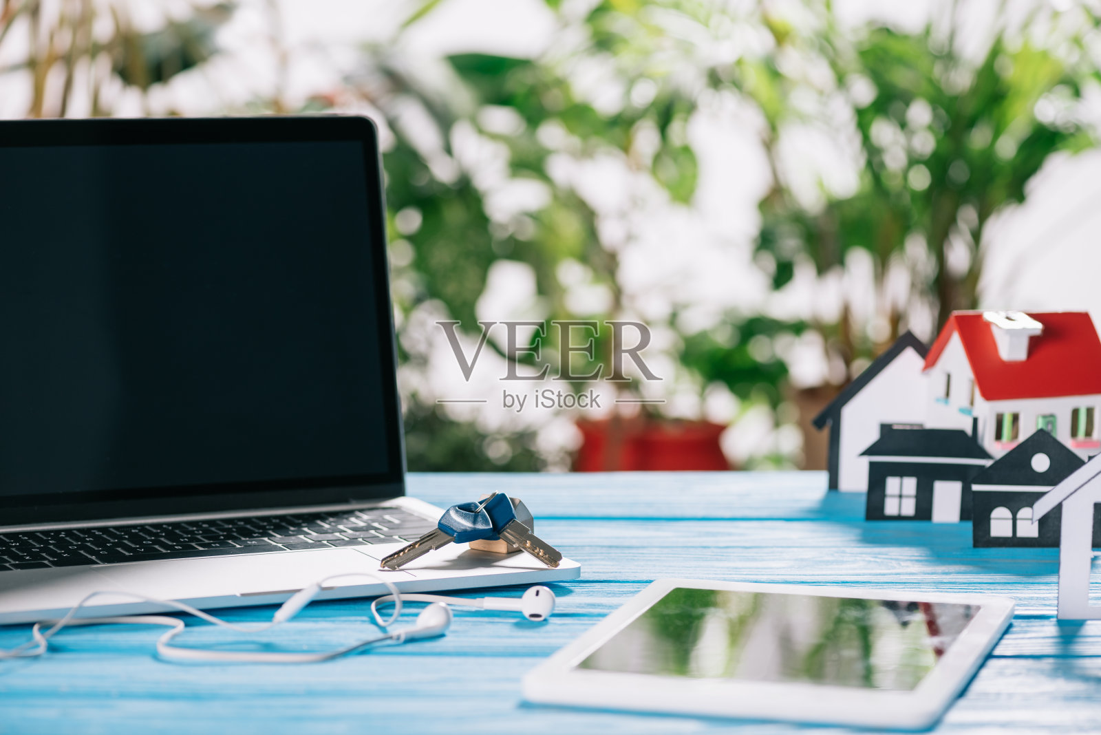 选择焦点的数字平板电脑，笔记本电脑的空白屏幕和靠近耳机和房屋模型的木制书桌，抵押概念照片摄影图片