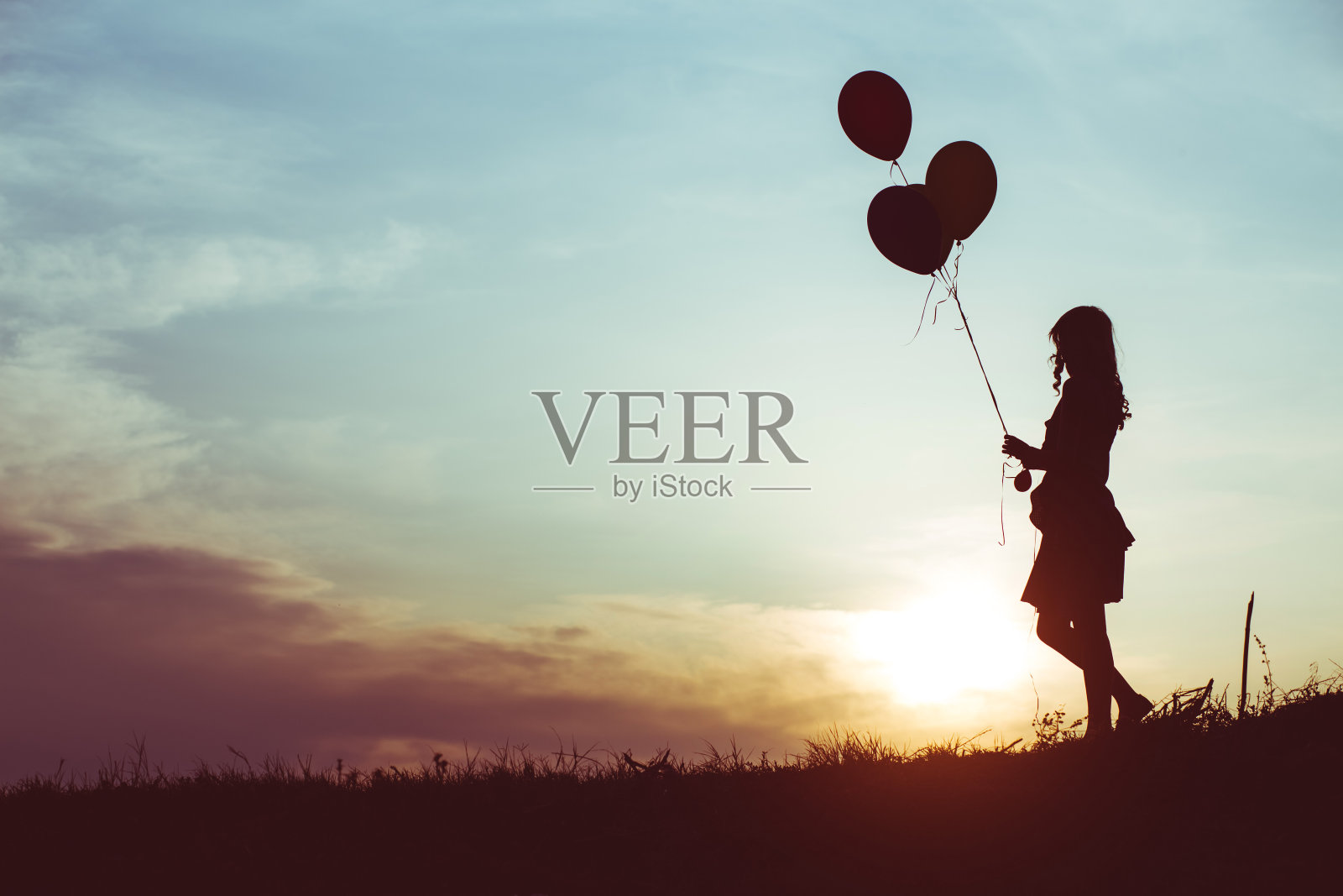 一个拿着气球的女人的剪影照片摄影图片