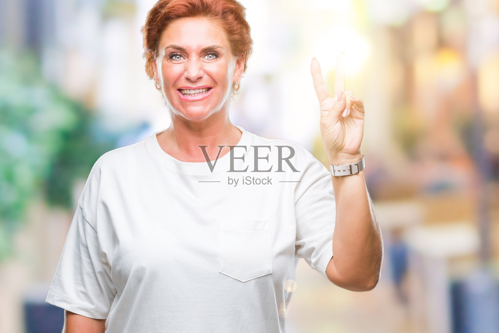 迷人的资深白种人红头发女人在孤立的背景显示和指向第二个手指，同时自信和快乐的微笑。照片摄影图片