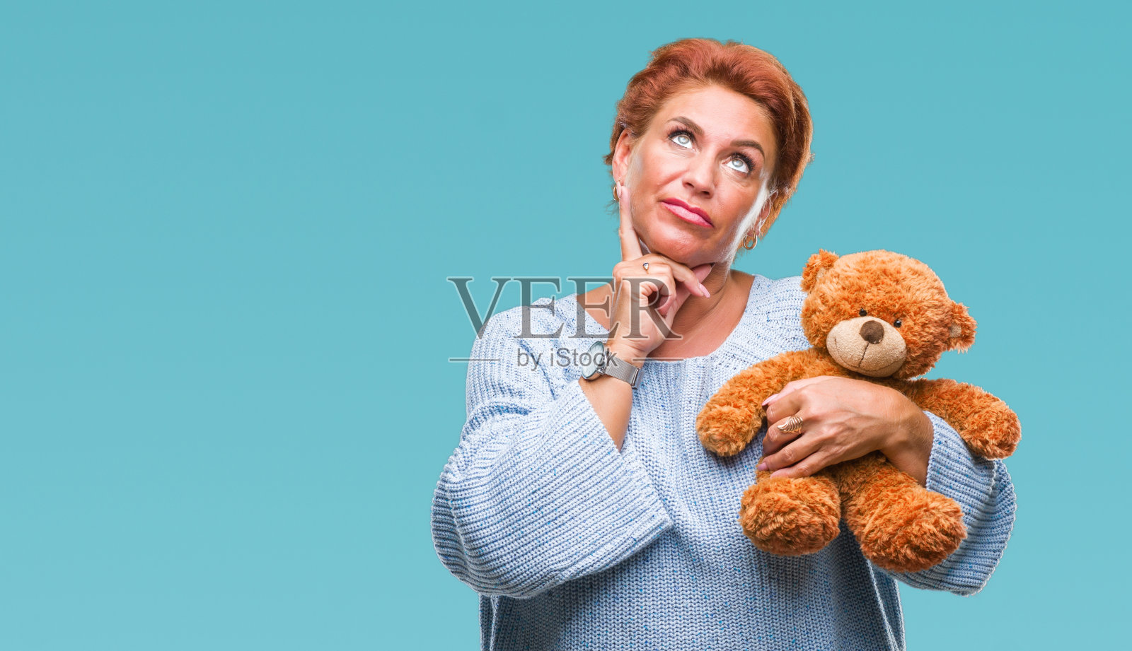 资深白种女子抱着泰迪熊过着孤立的背景严肃地面对思考问题，非常困惑的想法照片摄影图片