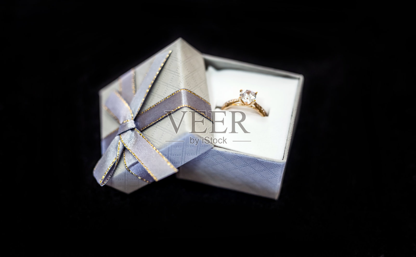 银色礼盒，黑色背景，金色戒指照片摄影图片