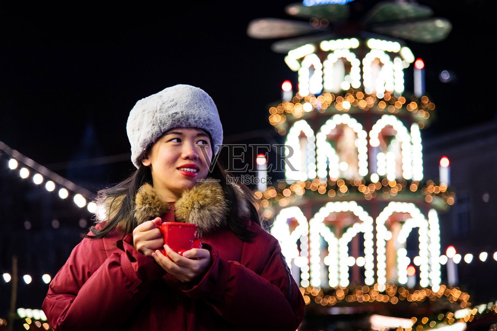 一个女人在冬天的夜晚喝着热饮照片摄影图片