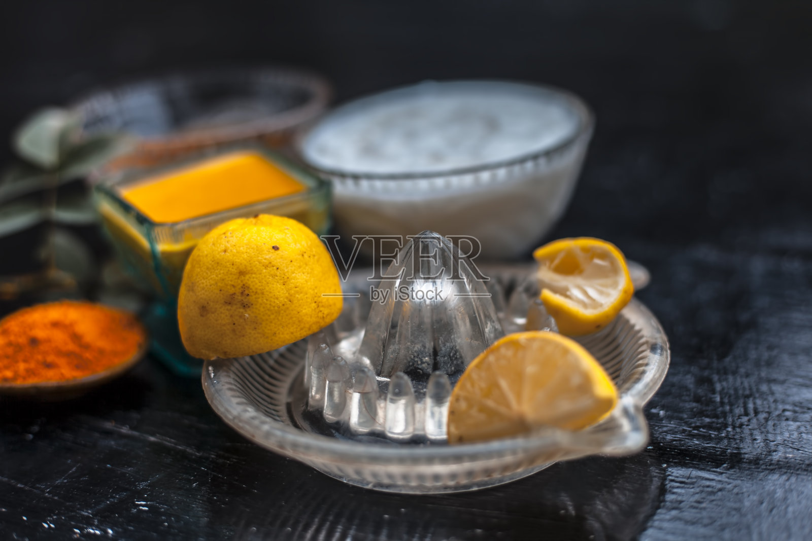 特写酸奶或凝乳的脸包与蜂蜜，柠檬汁，姜黄粉痤疮皮肤在木质表面的玻璃容器与生柠檬和姜黄粉。照片摄影图片