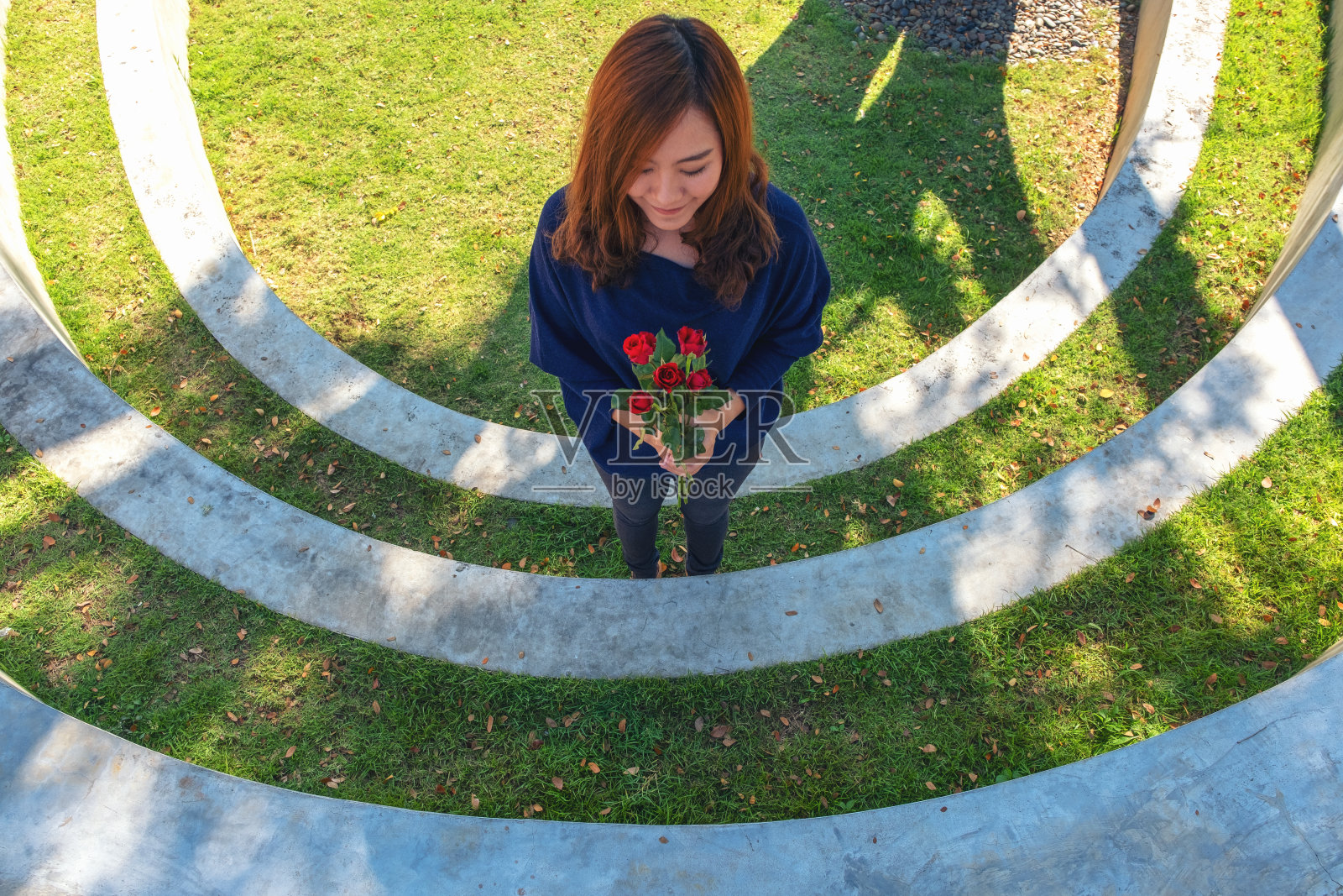 一个美丽的亚洲女人拿着红玫瑰花感觉快乐的情人节照片摄影图片