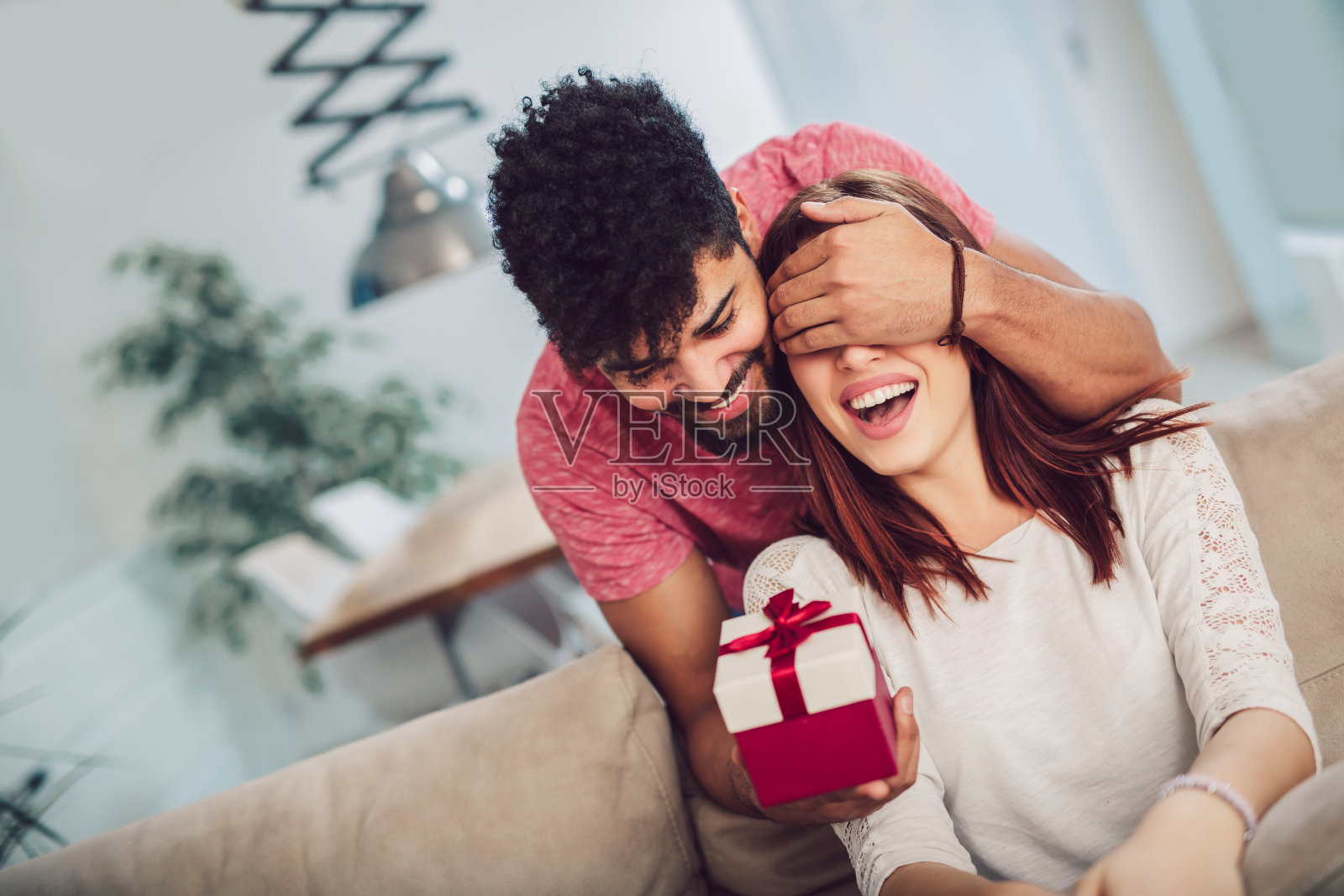 男人在家里给女人一个惊喜的礼物照片摄影图片
