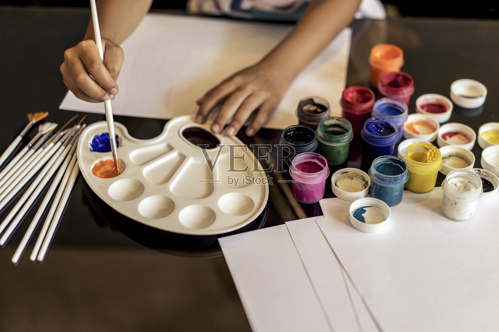 这个孩子在纸上画水彩画和水彩画照片摄影图片