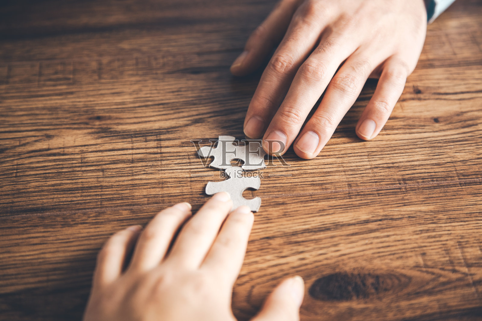 团队手拿拼图放在桌上照片摄影图片