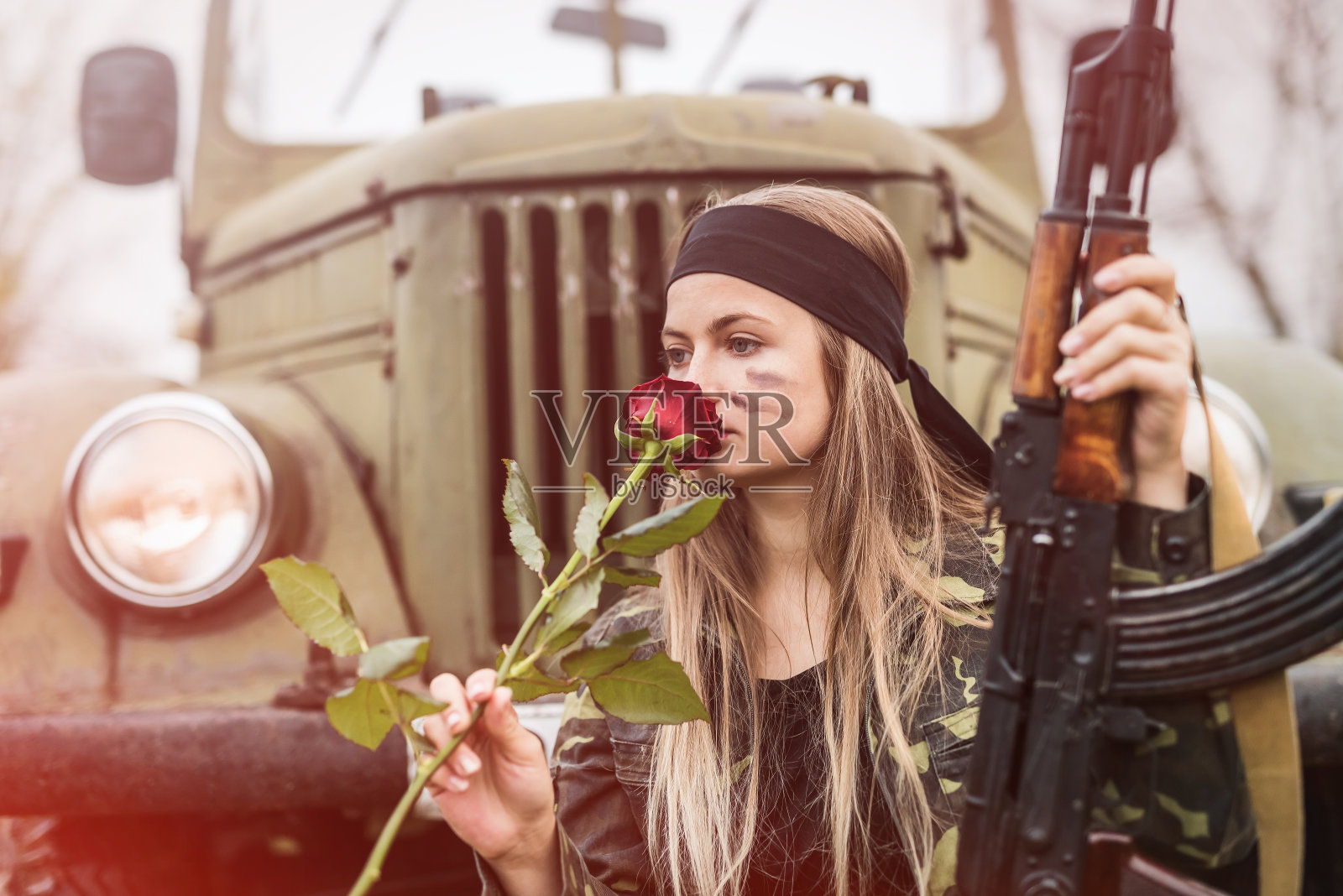 漂亮的士兵，带着玫瑰花和步枪照片摄影图片