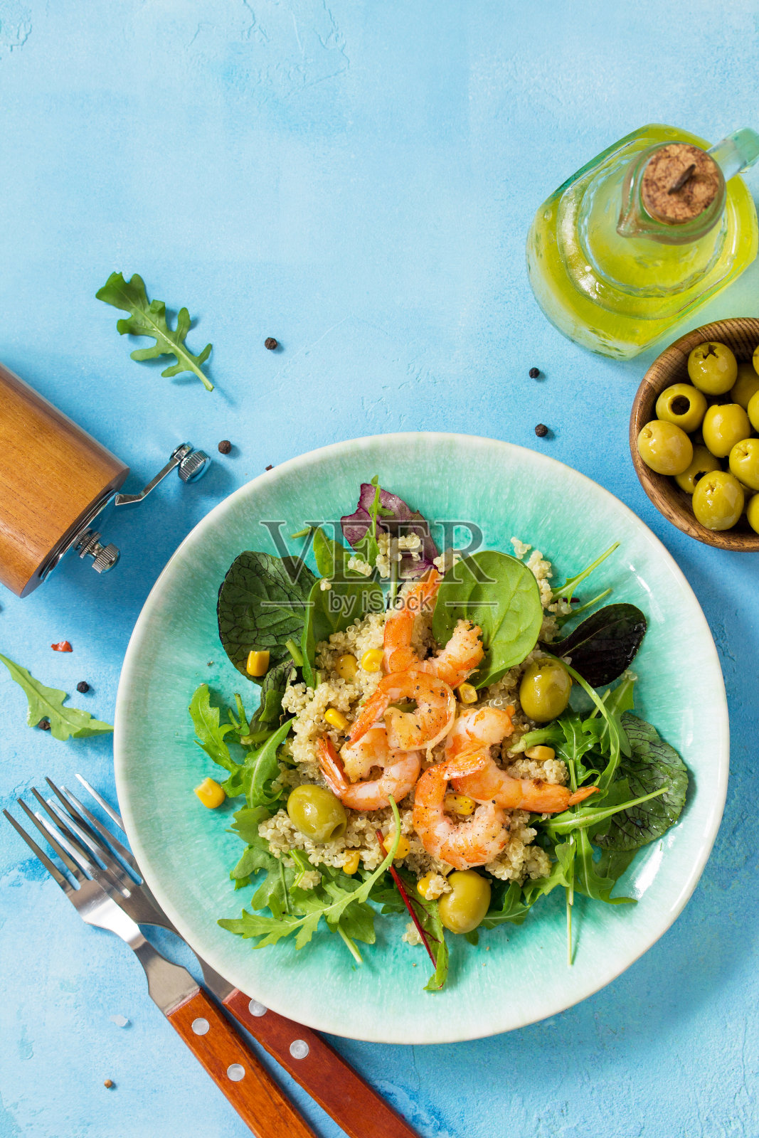 饮食菜单，素食。蓝石桌上的健康沙拉，有藜麦、芝麻菜、虾和橄榄。俯视图平铺背景。副本的空间。照片摄影图片