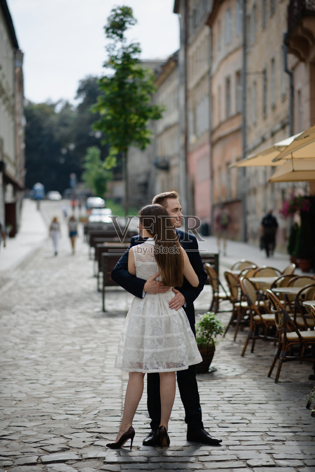 一对夫妇在街道上拥抱的全长侧视图照片摄影图片