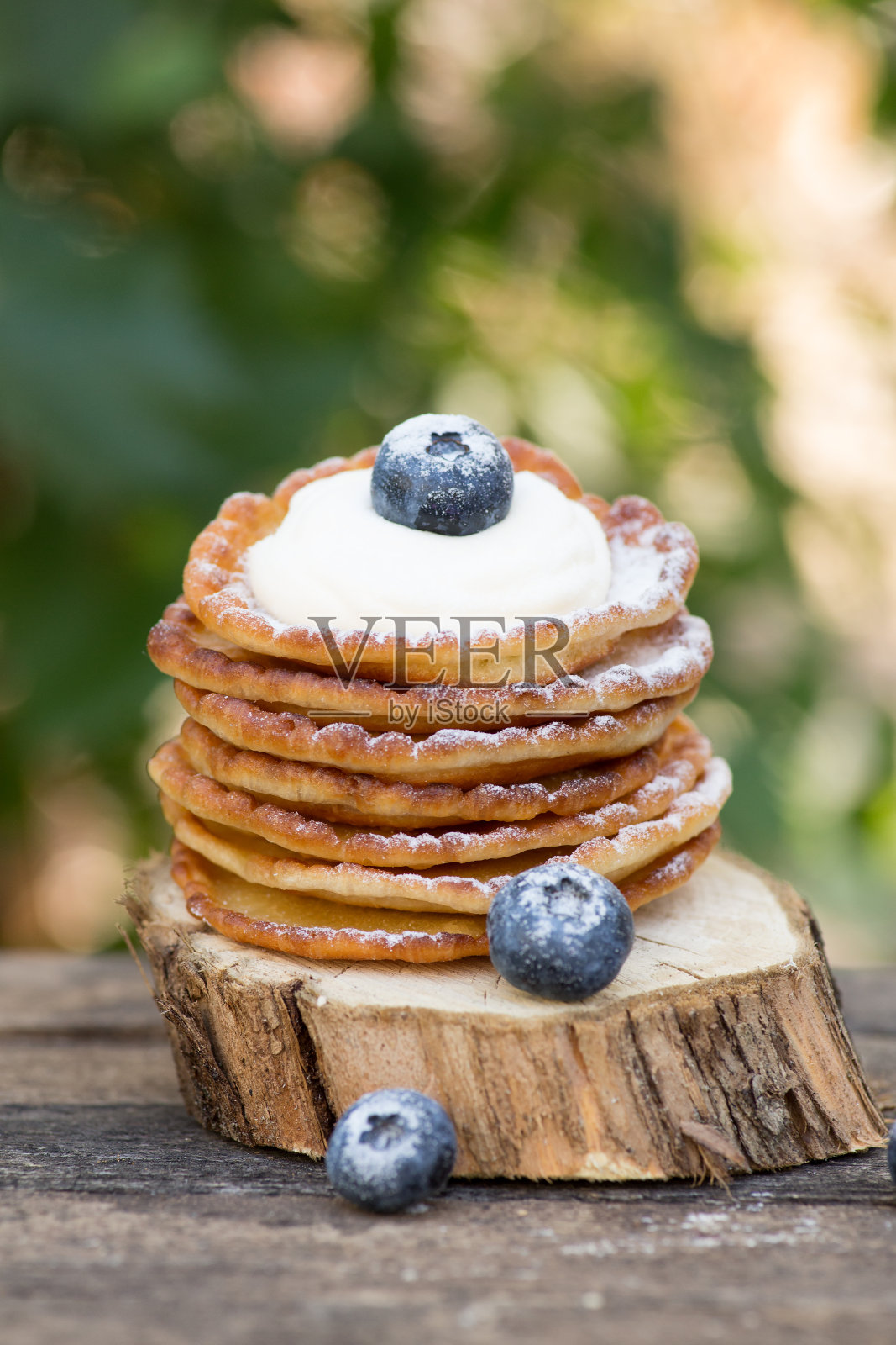 一堆美味的煎饼，上面有蜂蜜和蓝莓，背景是木头。与复制空间照片摄影图片