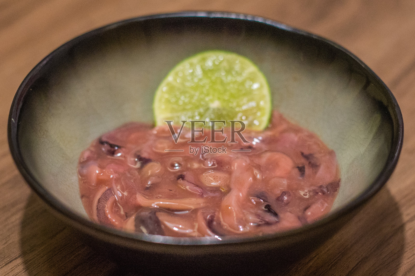 盐卡拉剁碎腌制过的咸鱿鱼和一块酸橙照片摄影图片