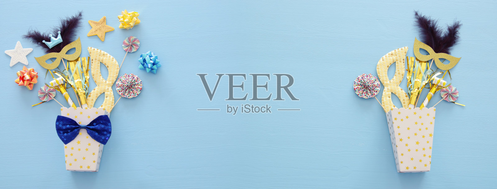 嘉年华派对庆祝概念与面具和彩色的派对配件在蓝色木制背景。前视图。平躺照片摄影图片