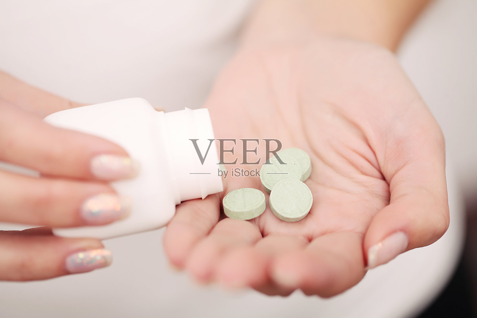 医学草药。草药药丸在手，掌心，手指与健康的药用植物。维生素补充剂用于护理，药物治疗照片摄影图片