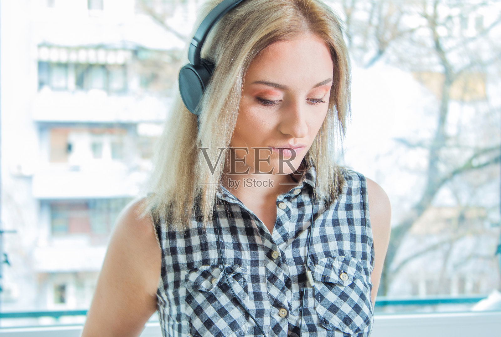 穿着格子衬衫听音乐的女孩照片摄影图片