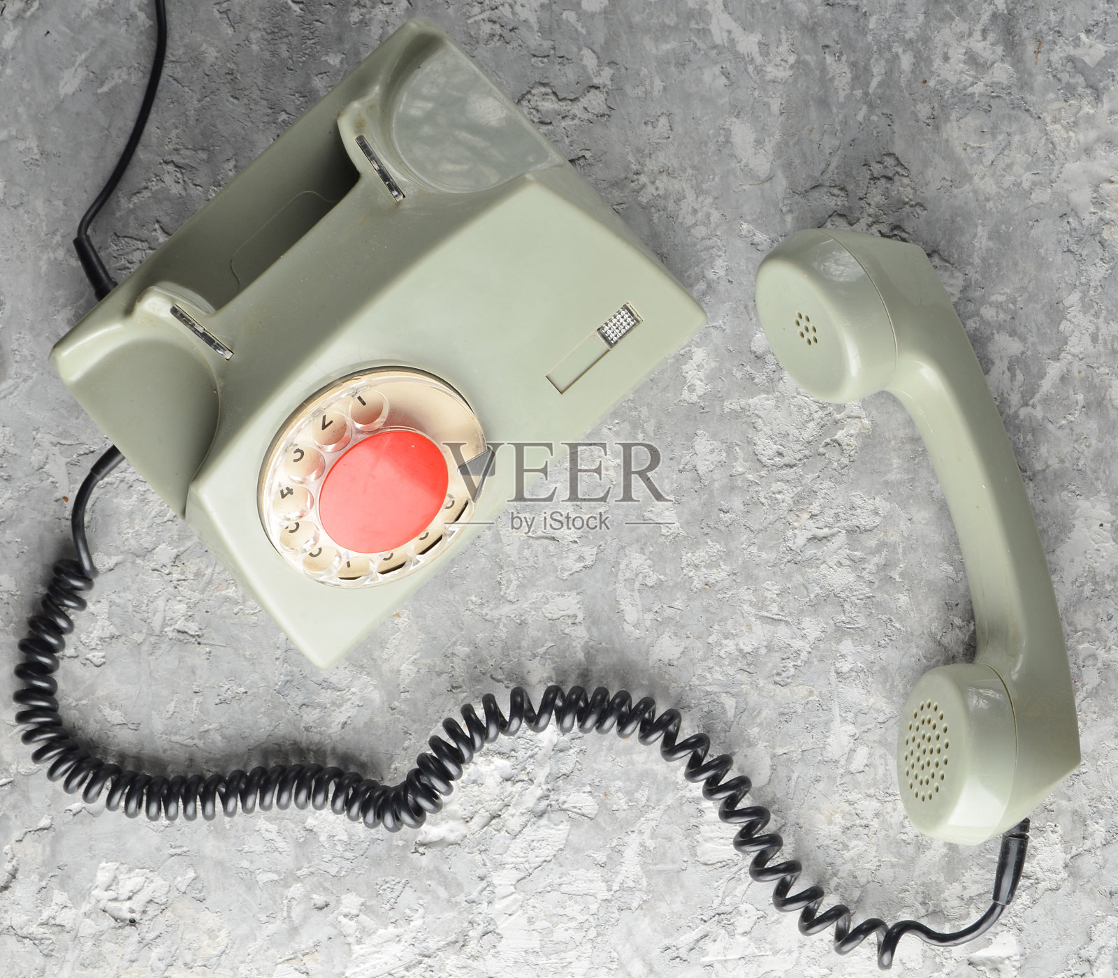 灰色混凝土背景上的老式旋转式电话。俯视图照片摄影图片