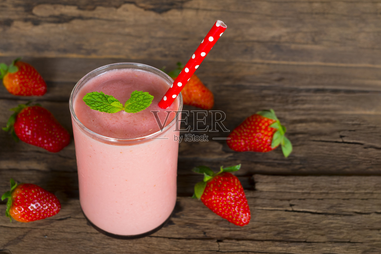 草莓冰沙果汁饮料健康的水果味道美味在玻璃饮料插曲早上在木头背景。照片摄影图片