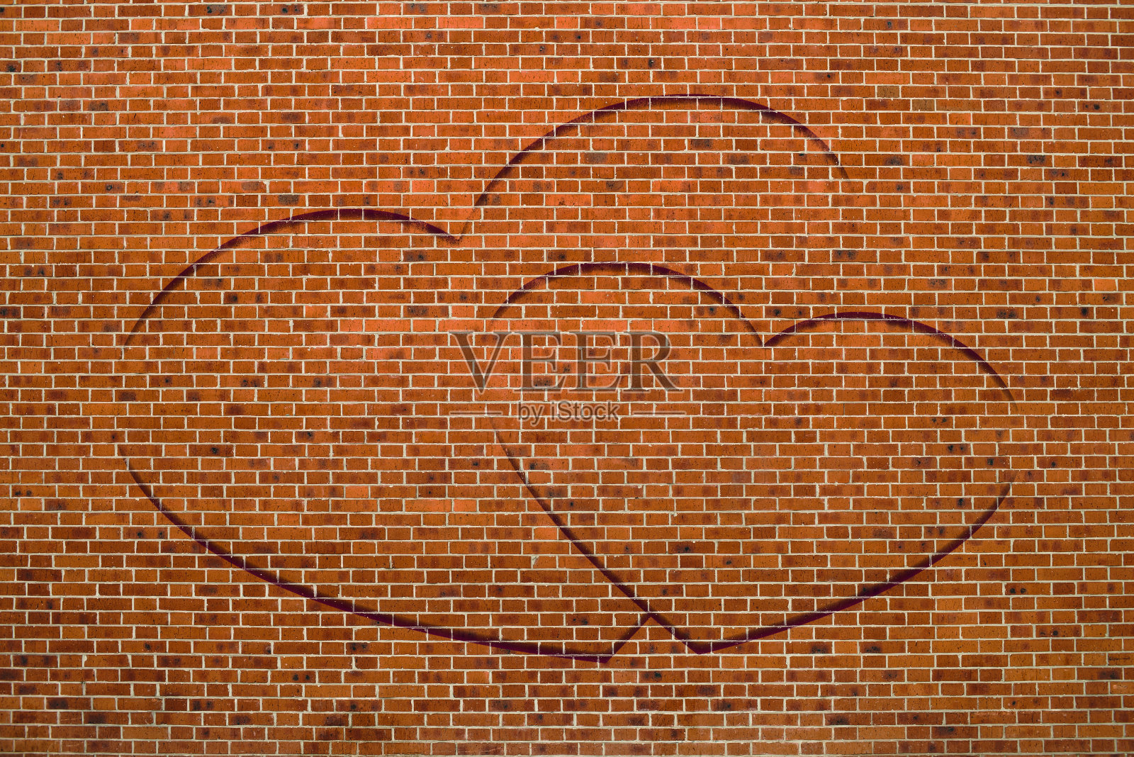 两颗画在棕色砖墙上的心特写。城市背景与两个绘制的心。不完美的外观和爱的象征涂鸦。情人节的形象。不理想的砖与复制空间。照片摄影图片