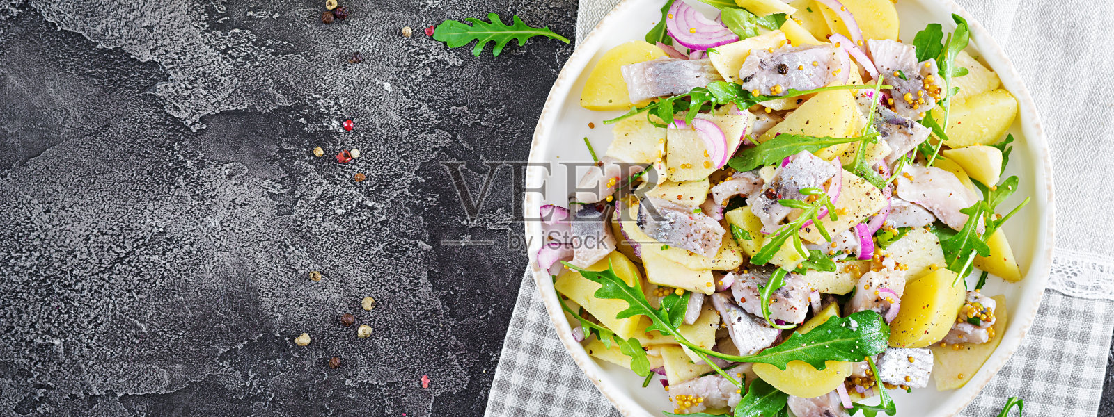 传统的咸鲱鱼片，新鲜苹果，红洋葱和土豆沙拉。犹太食品。北欧美食。横幅。前视图。平躺照片摄影图片