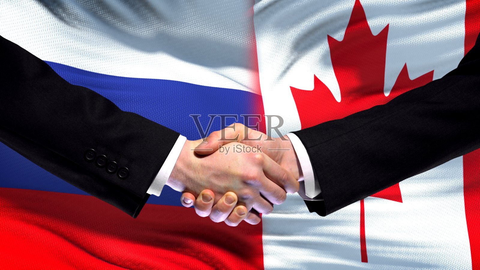 俄罗斯和加拿大握手，国际友谊峰会，旗帜背景照片摄影图片