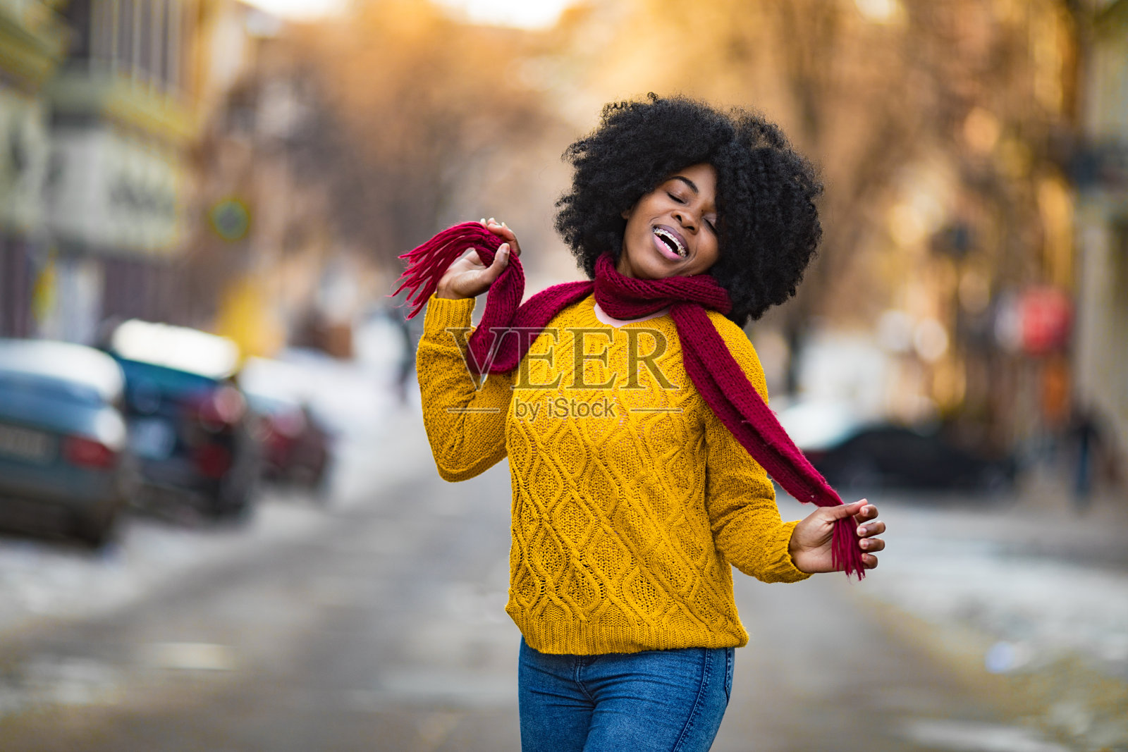 快乐的年轻黑人妇女正对着城市的街道微笑。照片摄影图片