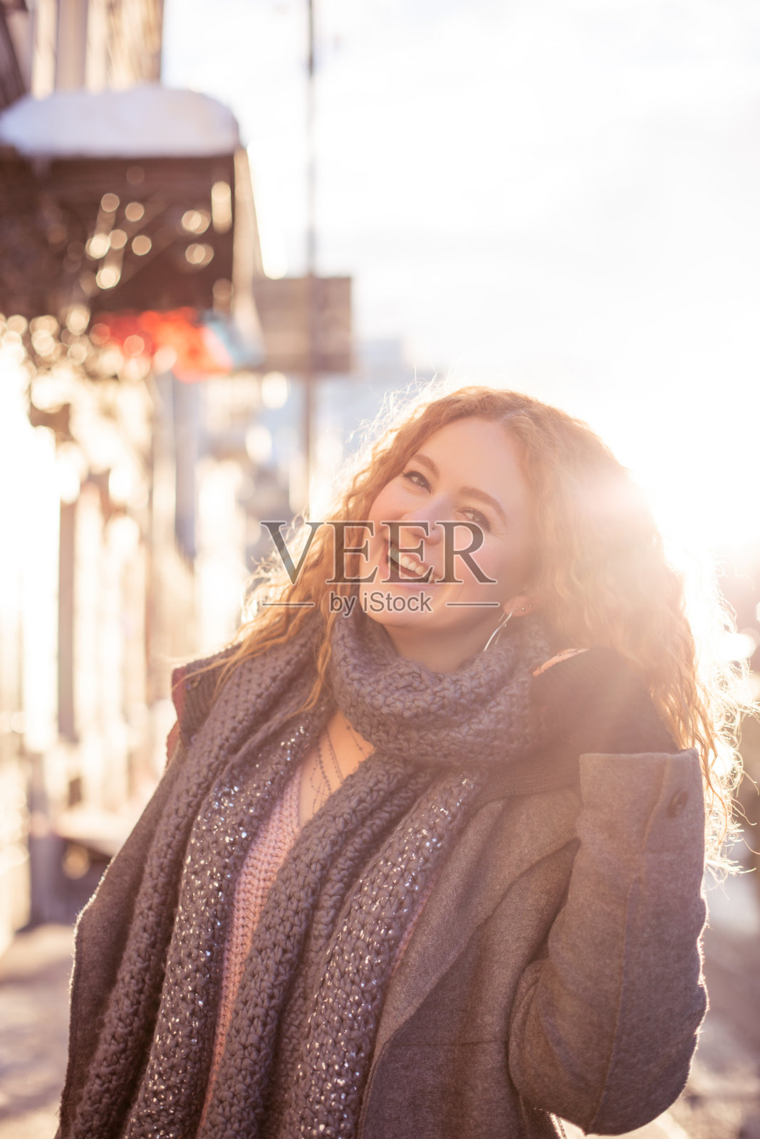 街上的肖像，迷人的红发女人卷头发穿着冬天的衣服。日落。照片摄影图片