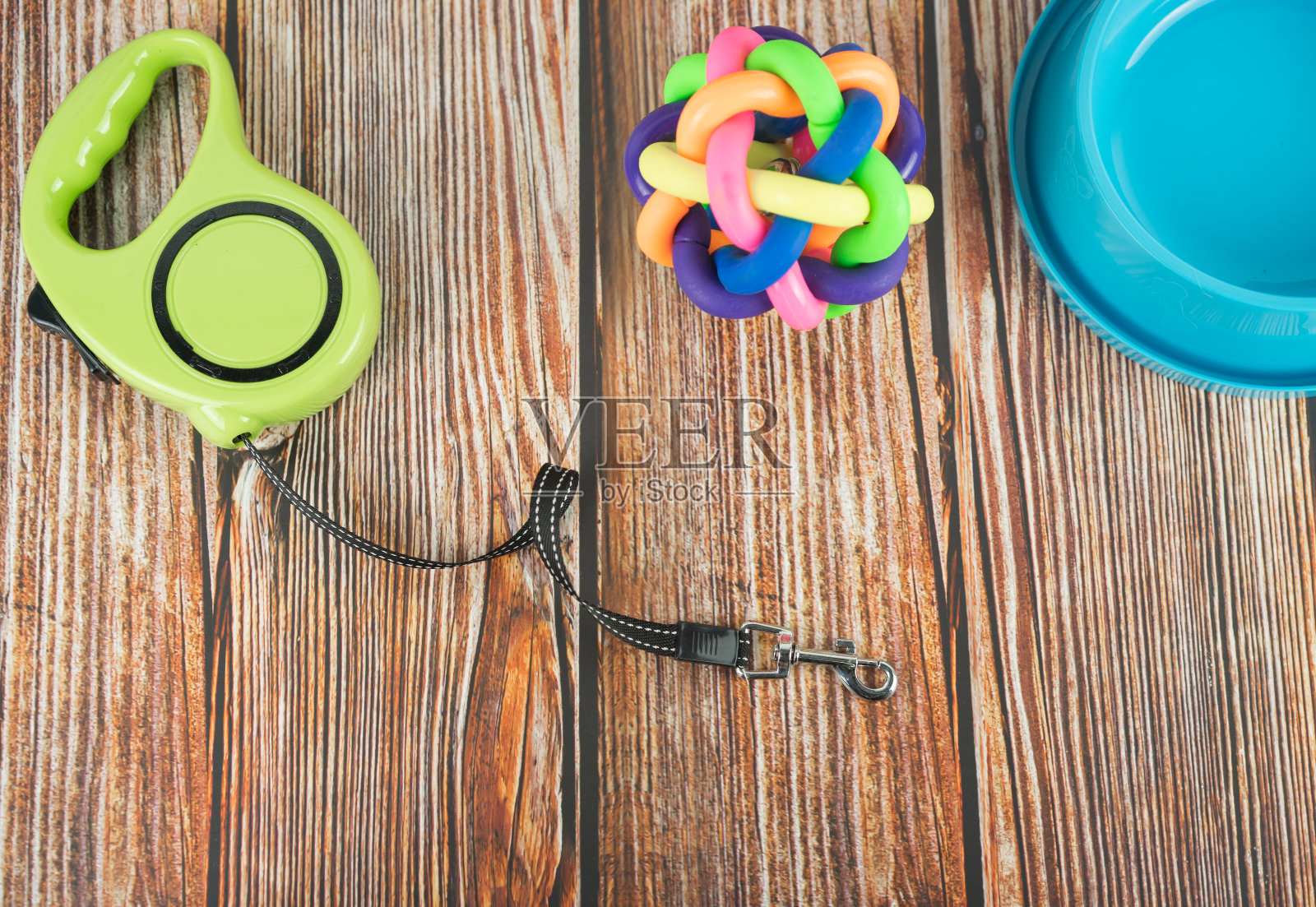 宠物饰品概念。宠物皮带与橡胶玩具和碗在木制背景。照片摄影图片