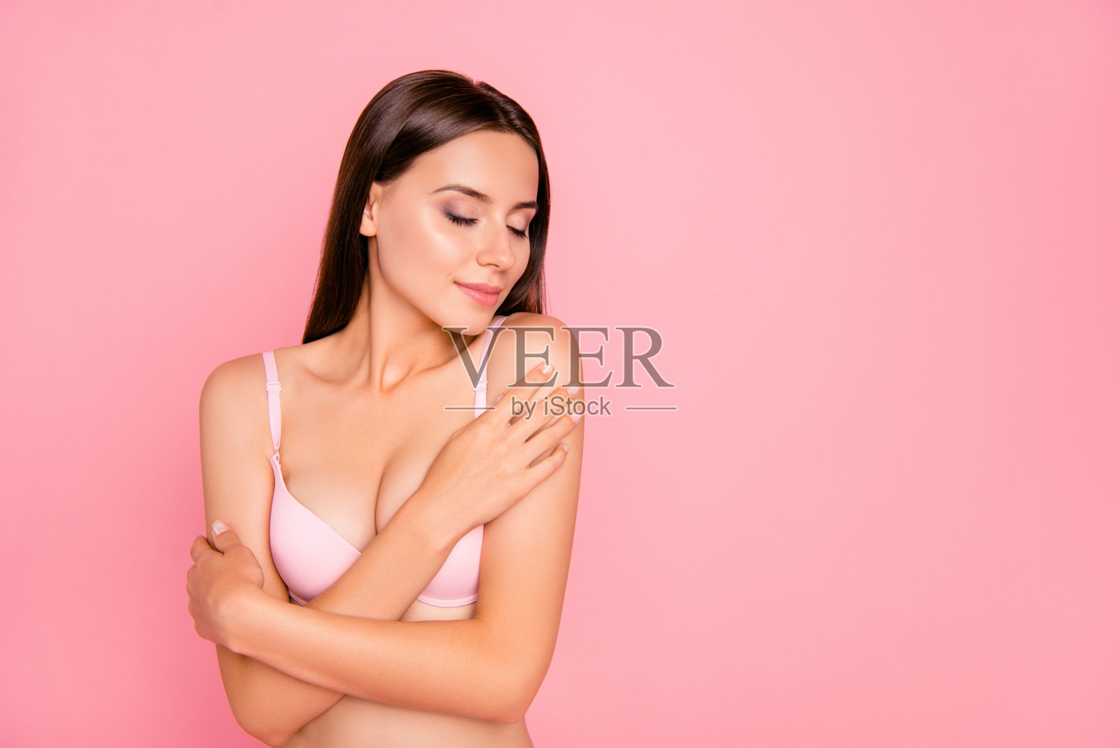 近距离的肖像可爱的，漂亮的，有吸引力的，温柔的，美丽的她，她的女孩闭上眼睛集中精力尝试新的味道，在粉红色的内衣孤立在粉红色的背景照片摄影图片