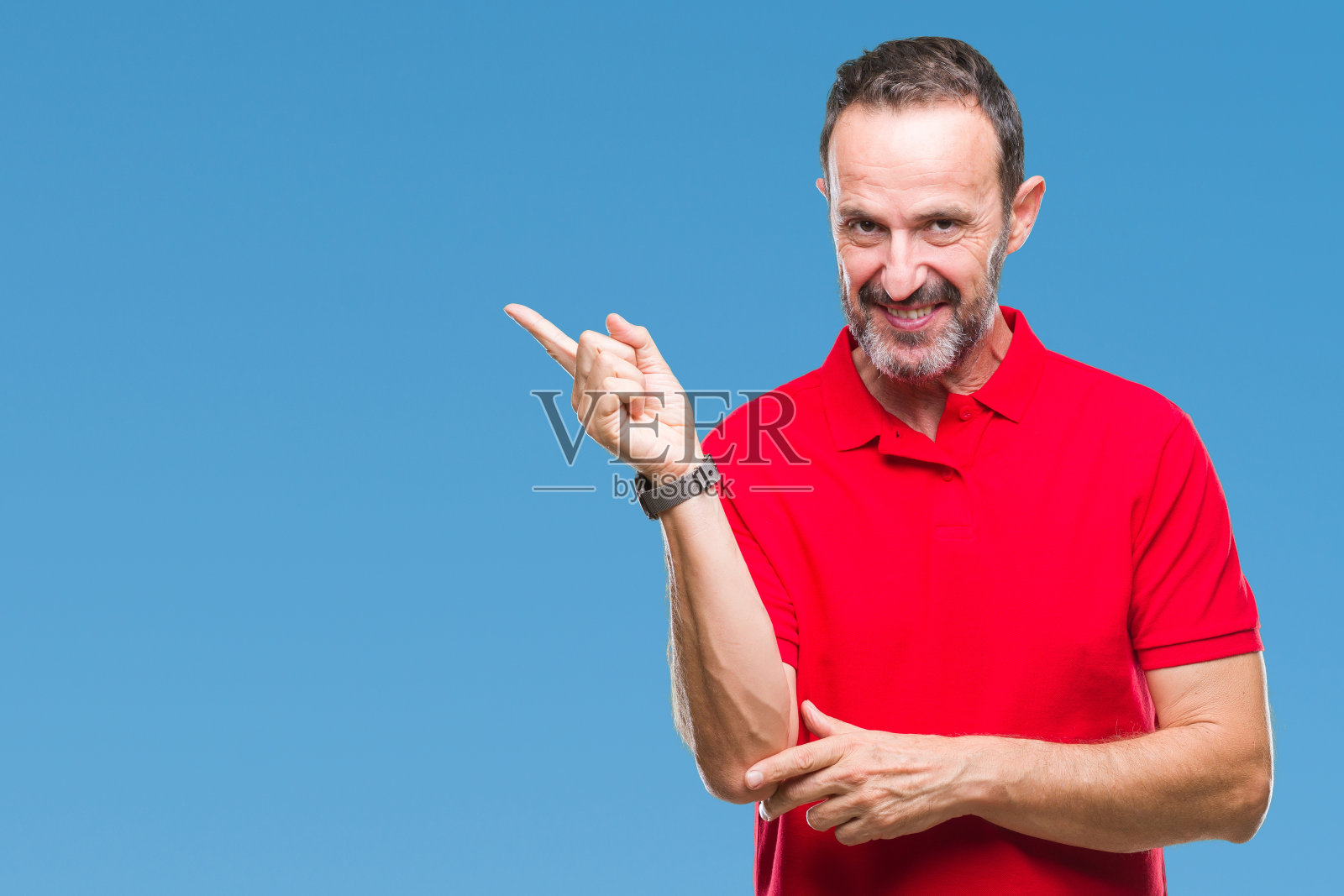 白发苍苍的中年老人隔着孤立的背景，脸上挂着大大的微笑，用手和手指指着一边看着镜头。照片摄影图片