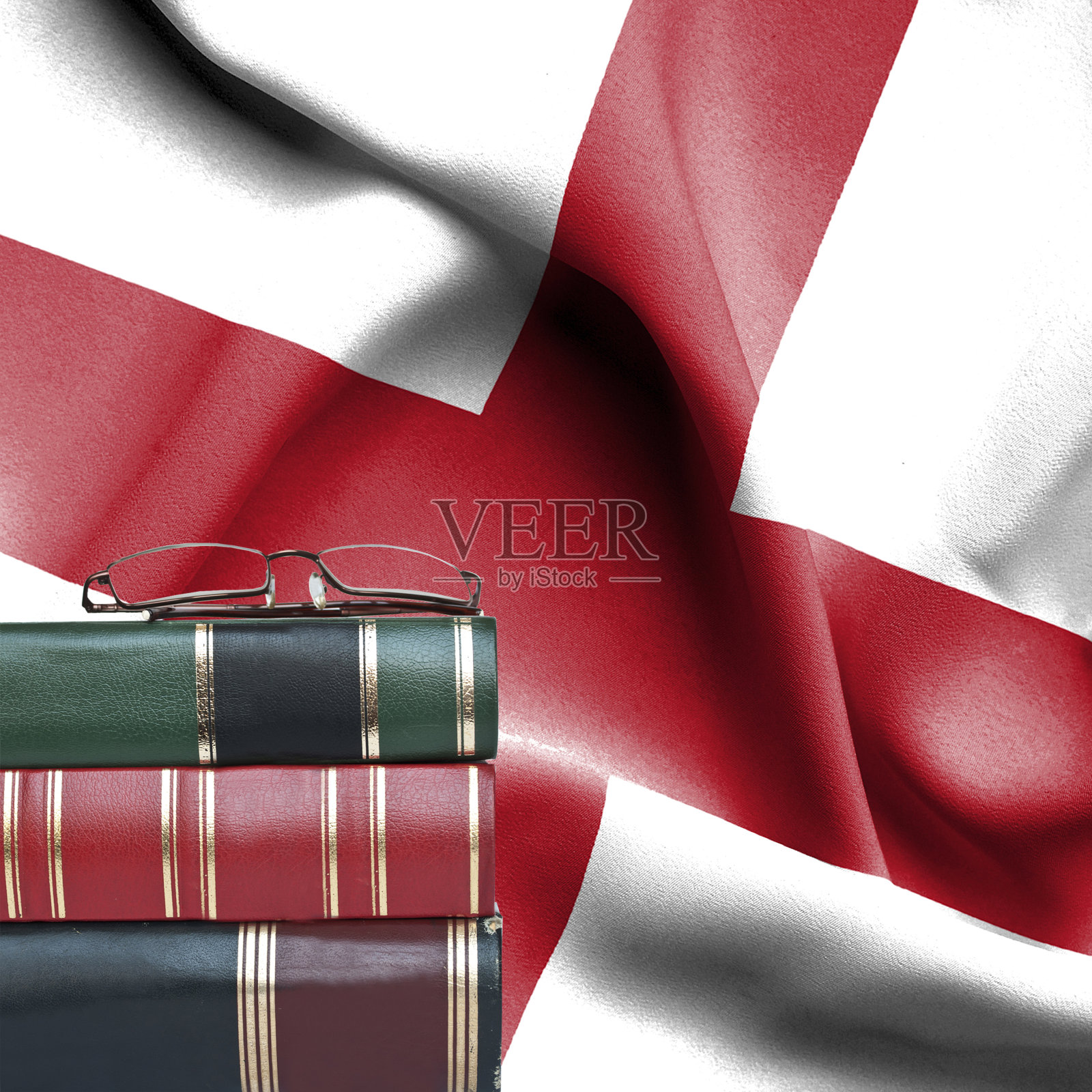 教育理念-叠书和老花镜对着英国国旗照片摄影图片