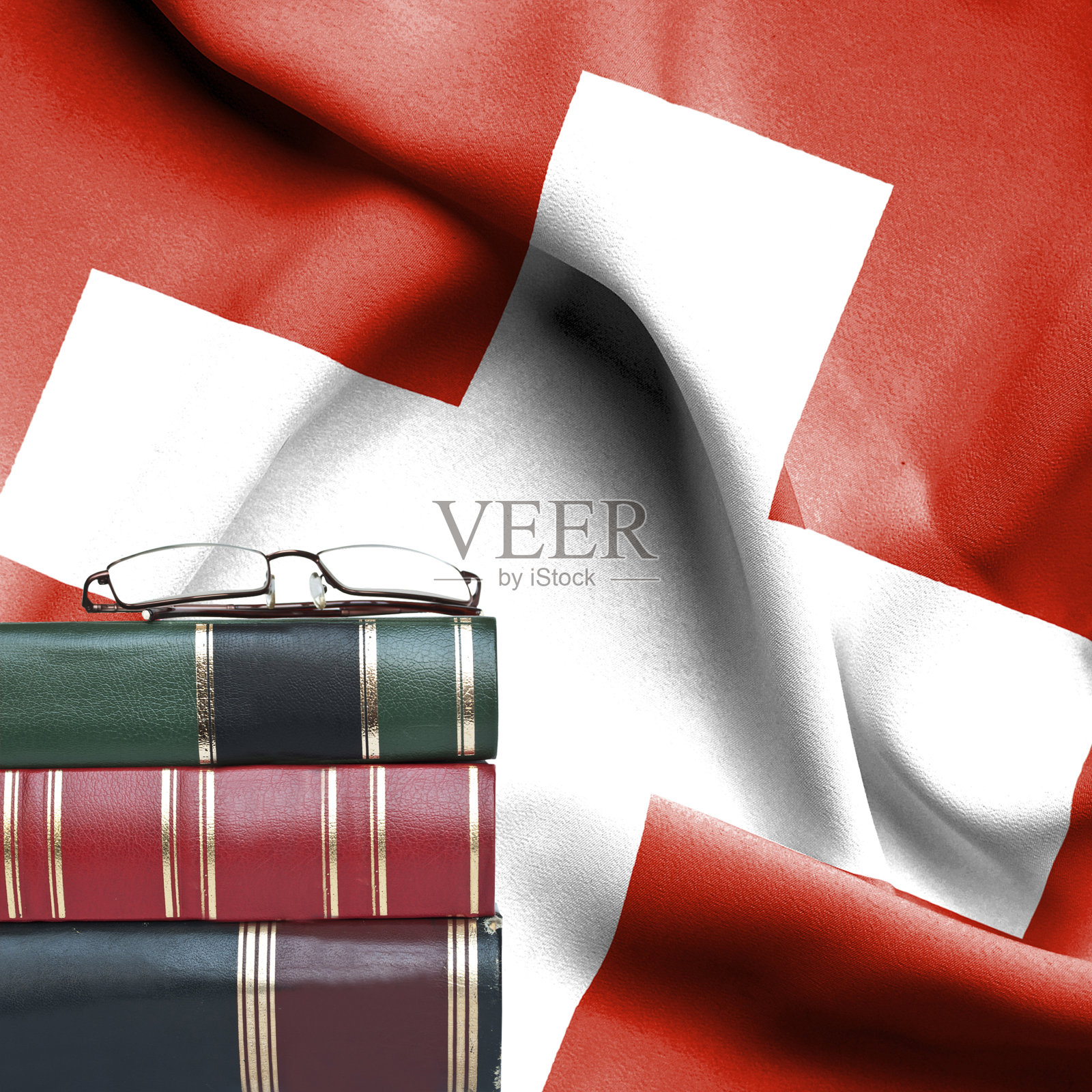 教育理念-书堆和老花镜对瑞士国旗照片摄影图片