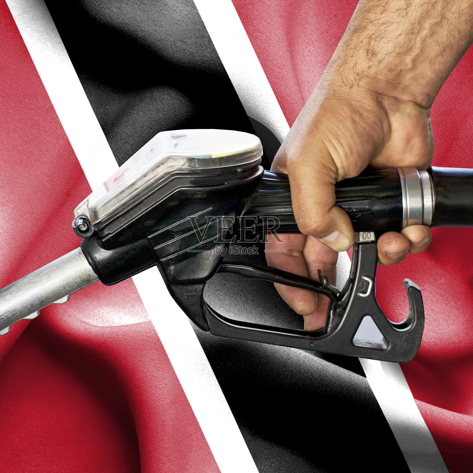 汽油消耗概念 - 手握软管，背景为特立尼达和多巴哥国旗照片摄影图片