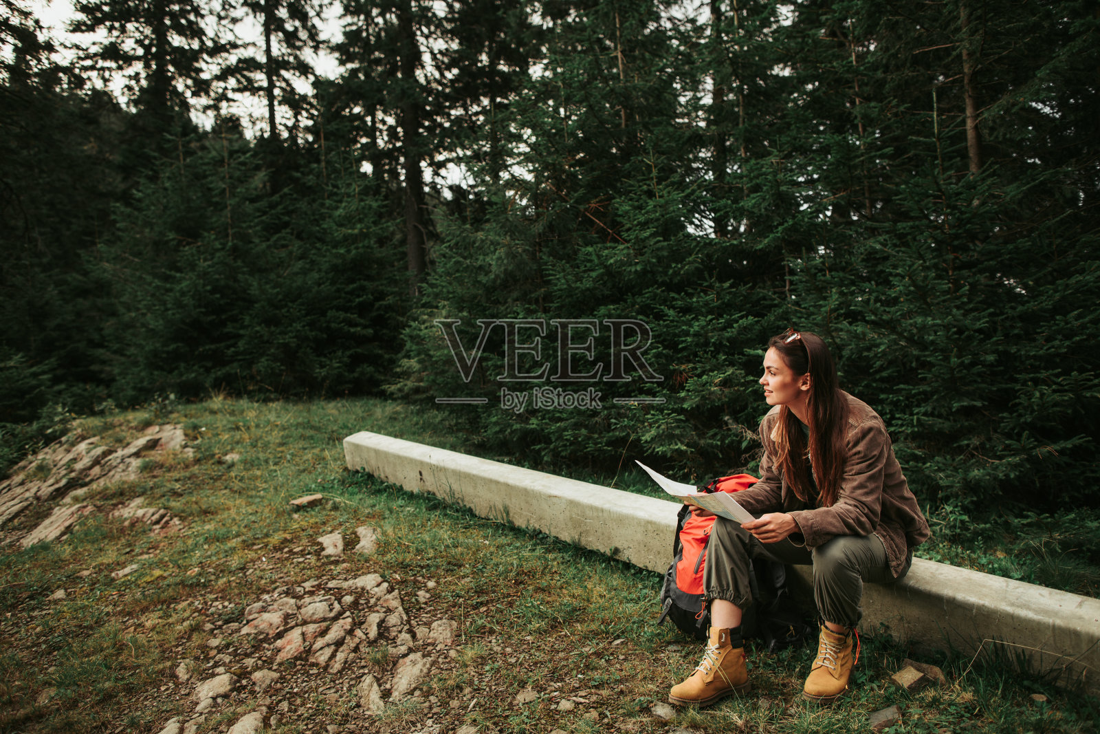 美丽的年轻女士拿着地图，在树林里寻找正确的道路照片摄影图片