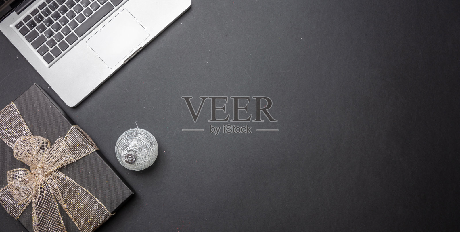 黑色礼品盒与闪亮的丝带在黑色办公桌，俯视图照片摄影图片